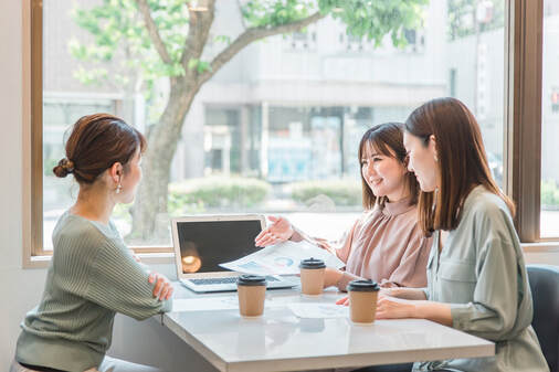 提案をする女性とそれを聞く2人の女性